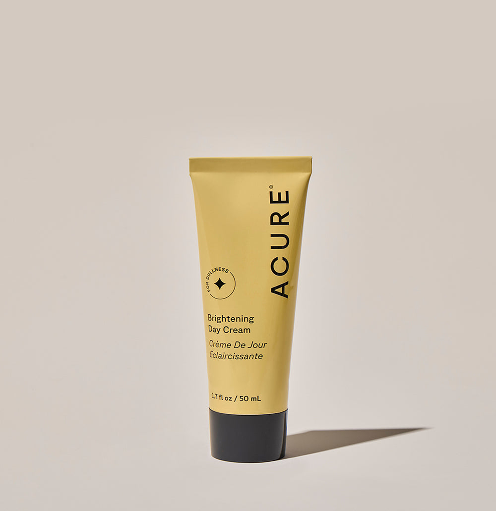 Acure Brightening Day Cream tube on a beige background