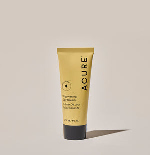 Acure Brightening Day Cream tube on a beige background